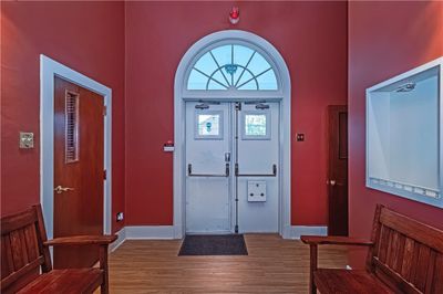 Here is a very generous foyer area with 2 large antique benches (included). On left is the Sound room, while on the right is a small hallway with 2 half baths and the stairways for up and down. | Image 3