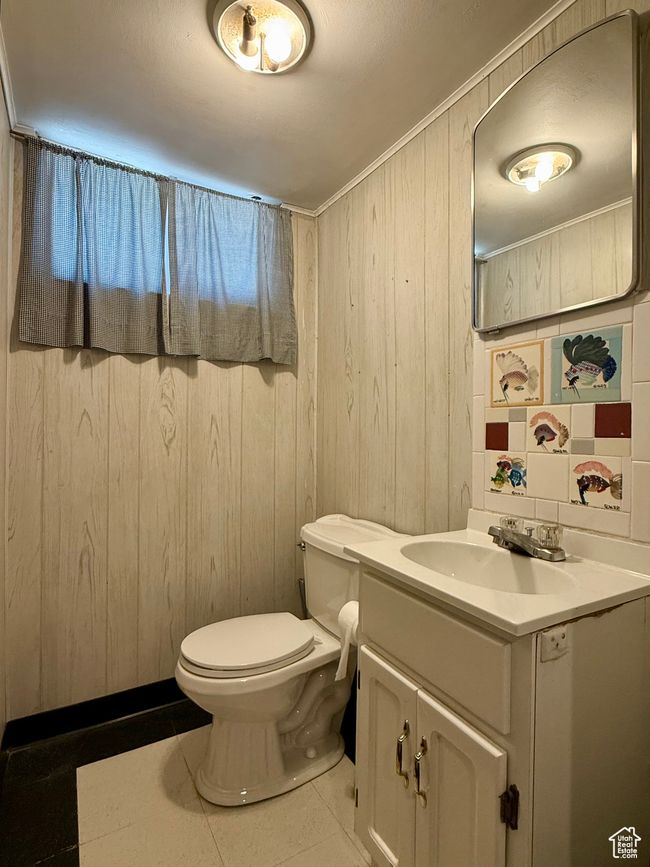 Bathroom featuring vanity, tile patterned flooring, toilet, and wood walls | Image 35