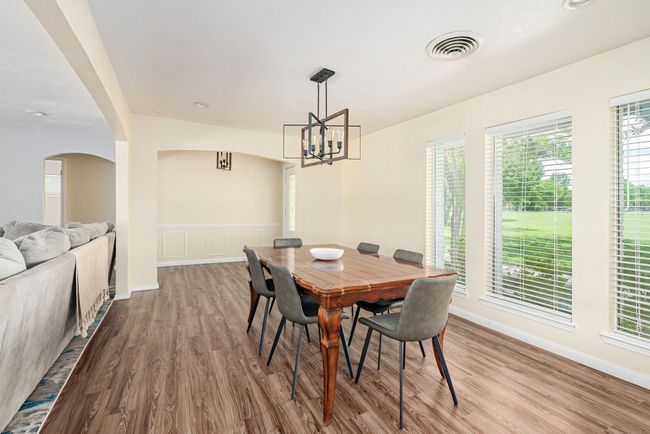 Dining room with a chandelier, wood finished floors, arched walkways, and baseboards | Image 19