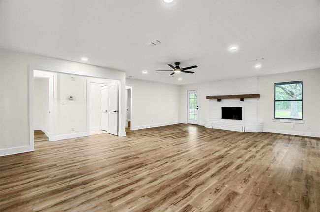 Unfurnished living room with a ceiling fan, healthy amount of natural light, wood finished floors, recessed lighting, and baseboards | Image 4