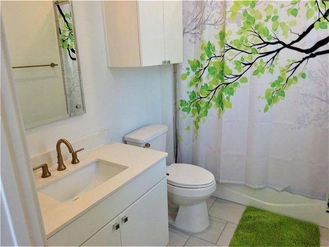 Bathroom with tile patterned flooring, toilet, vanity, and shower / bathtub combination with curtain | Image 7
