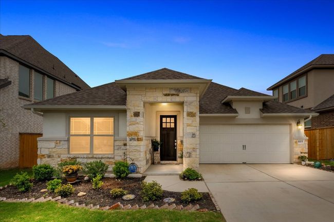 Prairie-style home featuring stone siding, a shingled roof, concrete driveway, and fence | Image 40