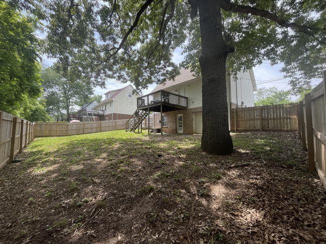 Enjoy privacy and space with this large backyard featuring a raised deck and mature trees. | Image 16