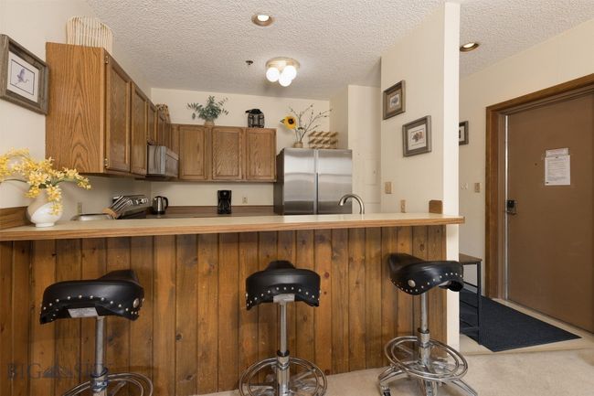 Kitchen with carpet, sink, a textured ceiling, kitchen peninsula, and stainless steel appliances | Image 14