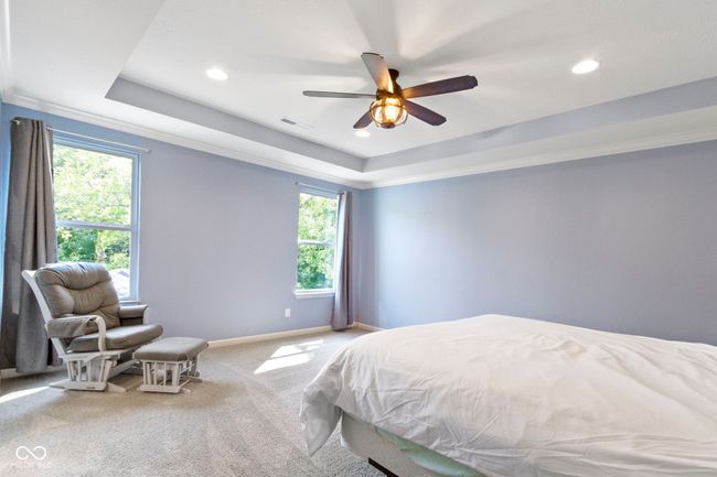 Spacious Primary bedroom features awesome views of the woods and a tray ceiling. | Image 31