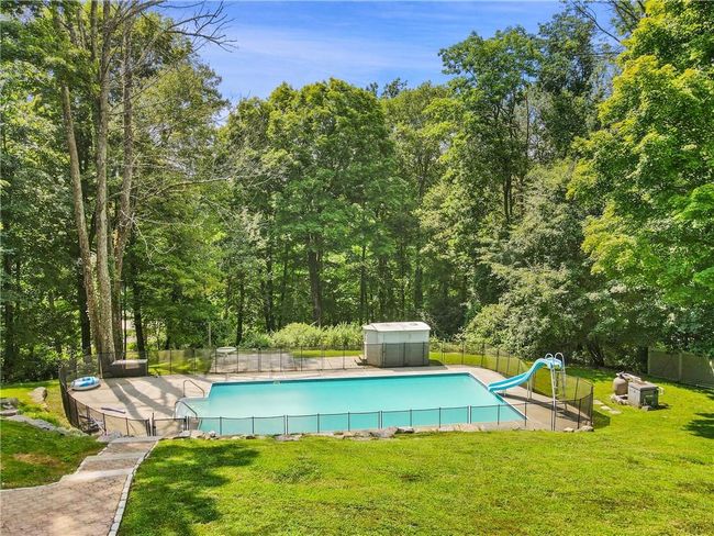 View of swimming pool with a water slide and a yard | Image 30