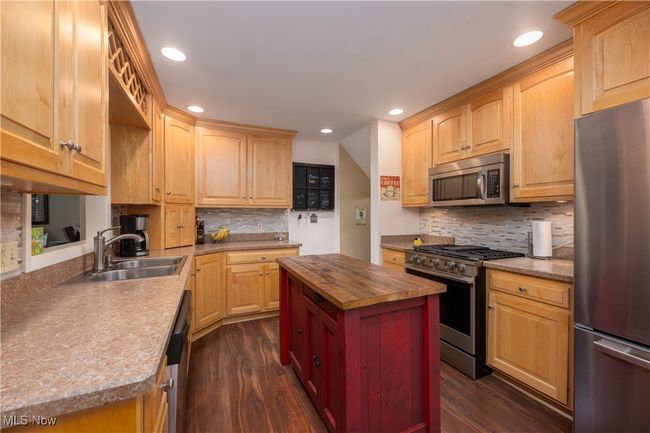 Kitchen with butcher block countertops, a sink, stainless steel appliances, and dark wood finished floors | Image 23