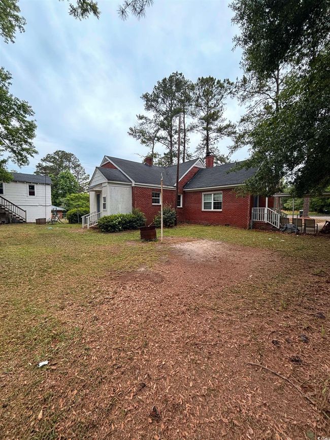 Back of property with a chimney, brick siding, and a yard | Image 7