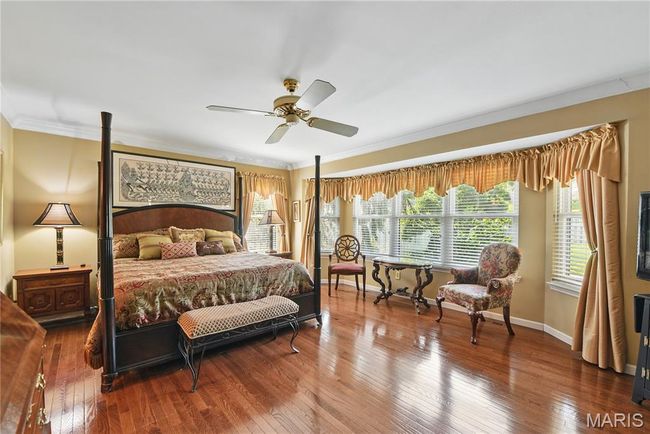 Bedroom with crown molding, hardwood / wood-style floors, and a ceiling fan | Image 10