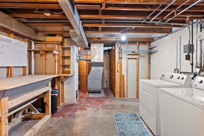 The laundry and utilities in the lower level. There is a workbench for projects on the left. | Image 18