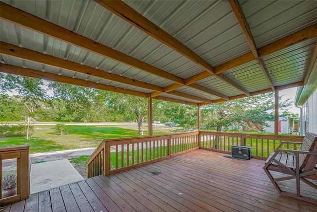As you enter, you'll notice the amazing details in the hardwood flooring and beams overhead, creating a warm and welcoming atmosphere. This property combines comfort with style, offering an ideal spot for both indoor and outdoor living. | Image 7