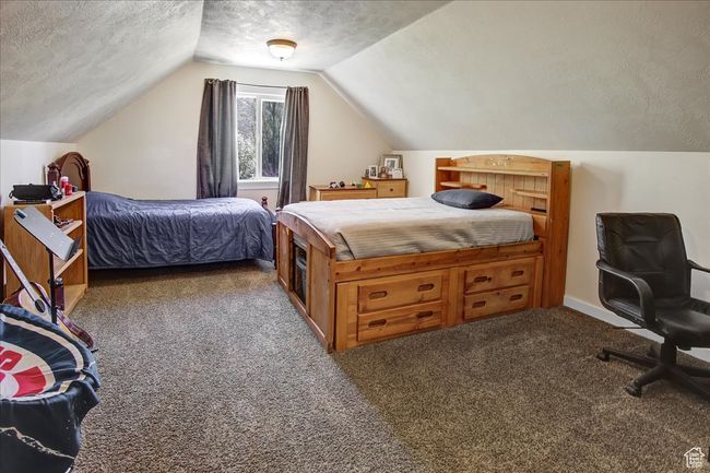 Bedroom featuring vaulted ceiling, carpet floors, and a textured ceiling | Image 18