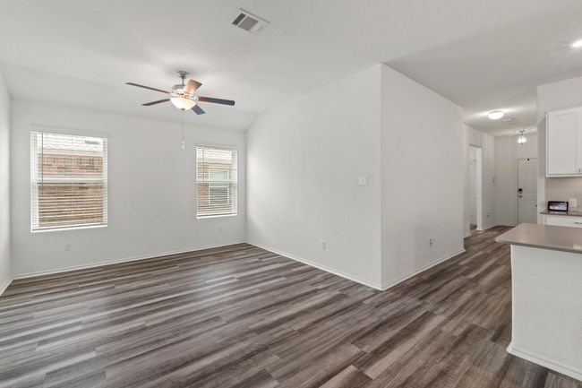 Open living space with ceiling fan is adjacent to the kitchen. | Image 15