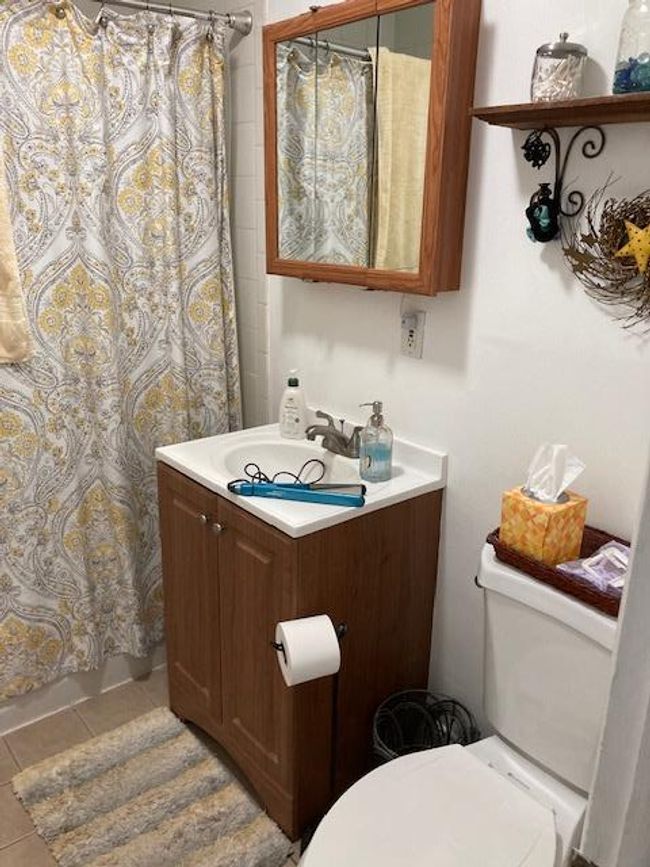 Bathroom with tile patterned flooring, vanity, and a shower with shower curtain | Image 8
