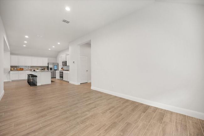 Unfurnished living room featuring light wood finished floors, recessed lighting, and vaulted ceiling | Image 24