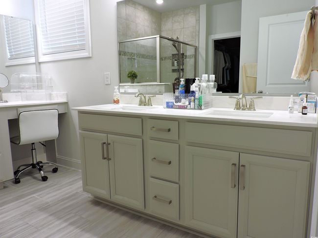 Bathroom featuring a shower stall, double vanity, and baseboards | Image 23