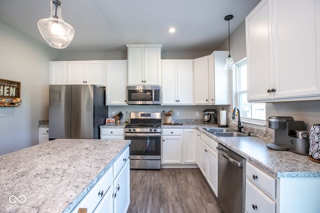 kitchen featuring stainless steel appliances, light countertops, white cabinetry, dark wood-style floors, and recessed lighting | Image 12