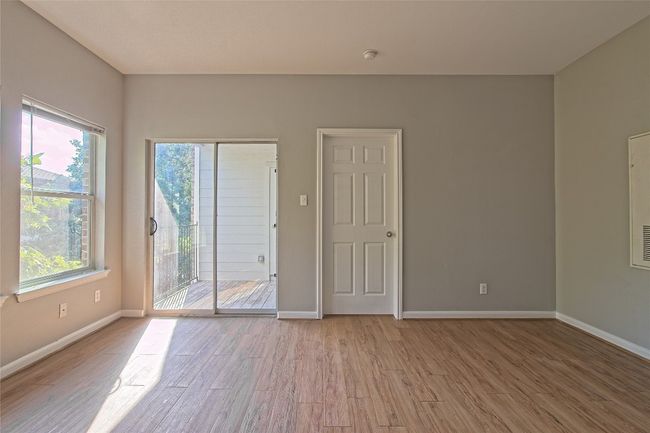 Empty room featuring healthy amount of natural light, light wood-type flooring, and a smoke detector | Image 13