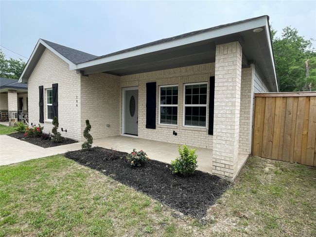 Ranch-style home featuring brick siding, fence, and a porch | Image 5