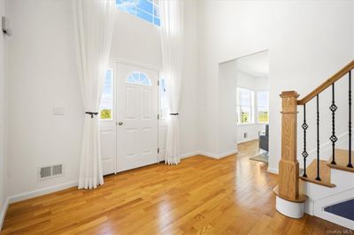 This beautiful entry, features high ceilings, custom drapes, plenty of natural light, and gleaming hardwood floors. | Image 2