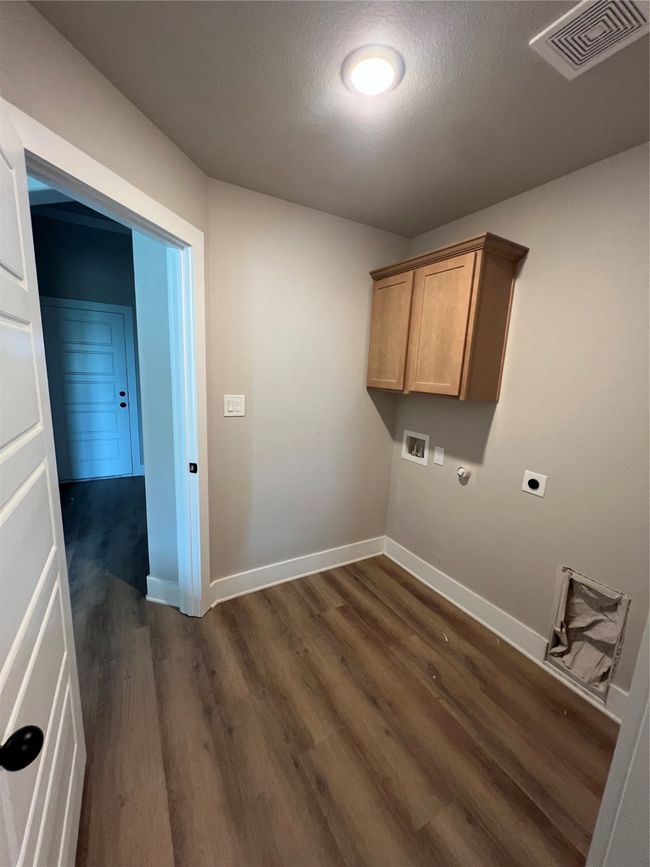 Laundry room featuring hookup for an electric dryer, dark wood-style flooring, baseboards, visible vents, and hookup for a washing machine | Image 12