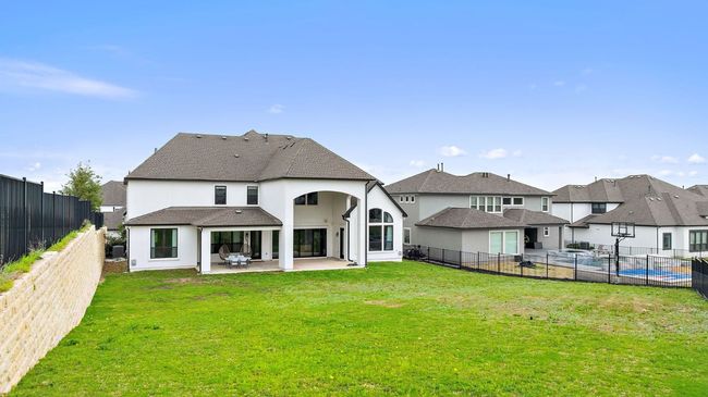 Back of property featuring a fenced backyard, a patio, a lawn, and stucco siding | Image 39