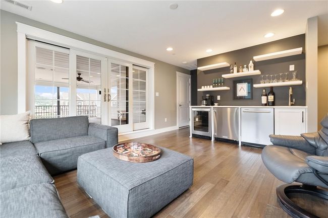 Third floor Family Room with hardwood floor and wet bar! Sliding doors to enormous covered deck with low maintenance floor and railing. | Image 34