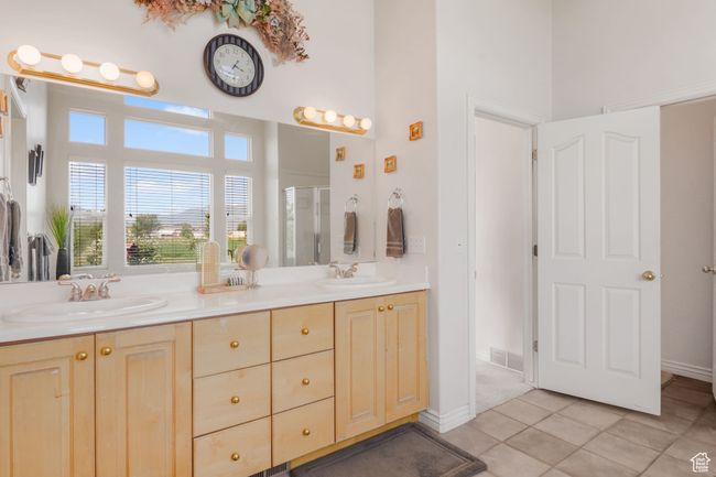 Bathroom with tile patterned floors, a stall shower, a towering ceiling, and a sink | Image 11