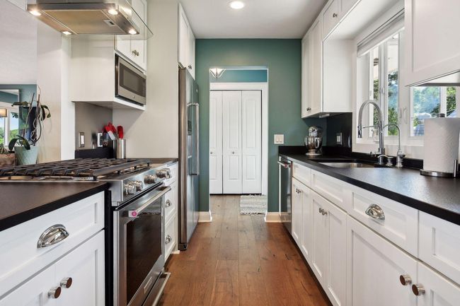 Black granite counter with a leather finish does not show fingerprints and is easy care. Many cabinets have pull outs for easy access. | Image 14