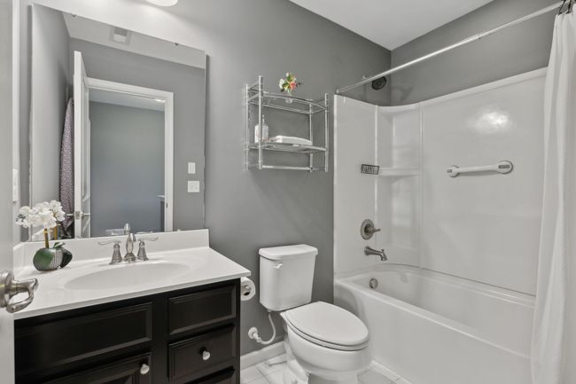 Bath two is tub/shower combo with single vanity and tile flooring | Image 26