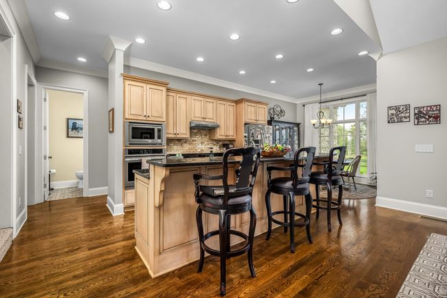 The island with an eating bar integrates dining and cooking, perfect for casual meals. | Image 39