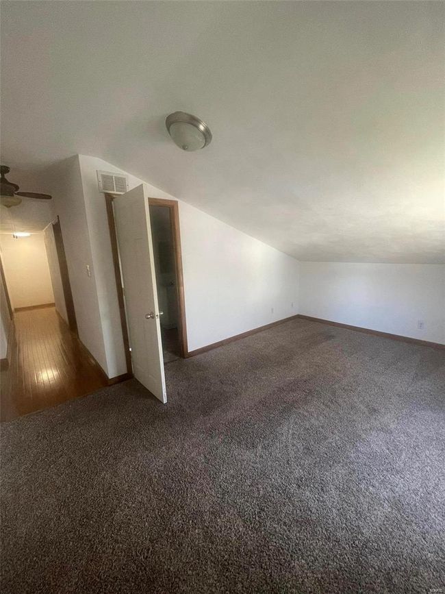Unfurnished room with visible vents, baseboards, ceiling fan, lofted ceiling, and carpet floors | Image 13