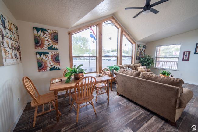 Living room featuring vaulted ceiling, a textured ceiling, dark wood-style floors, and ceiling fan | Image 5