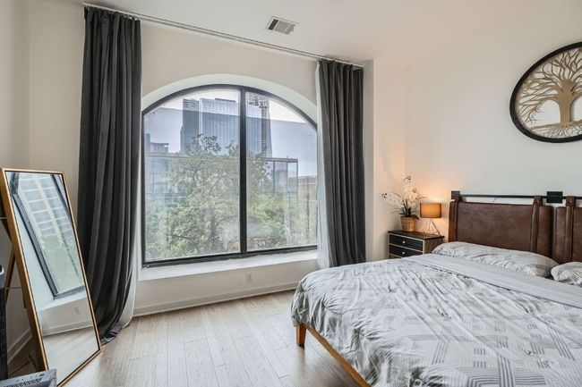Bedroom with multiple windows, visible vents, wood finished floors, and baseboards | Image 13