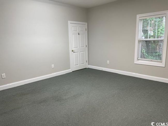 Spare room featuring baseboards and dark colored carpet | Image 6