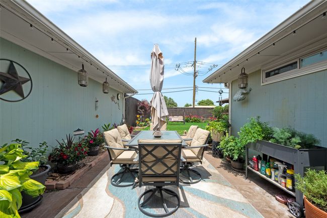 View of patio with outdoor dining space and fence | Image 30