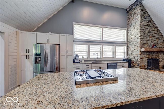 long kitchen island with range/oven built around it. | Image 23