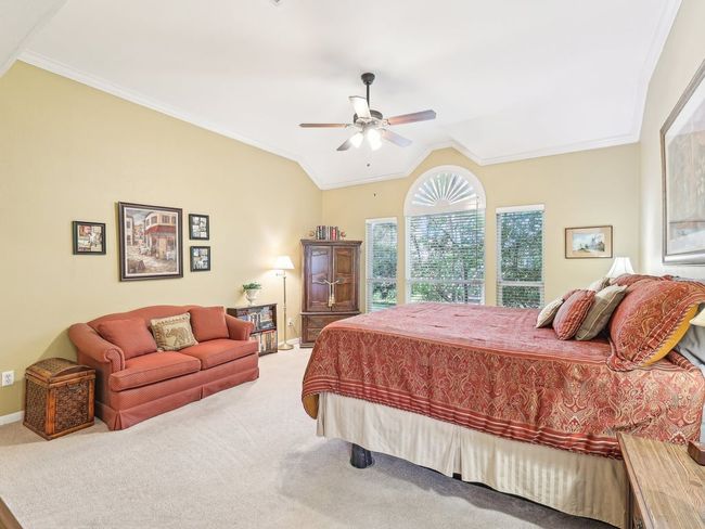 Bedroom featuring carpet floors, vaulted ceiling, crown molding, a ceiling fan, and baseboards | Image 17