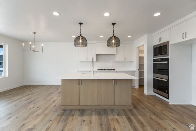 Kitchen with built in microwave, double oven, light countertops, recessed lighting, and light wood finished floors | Image 4