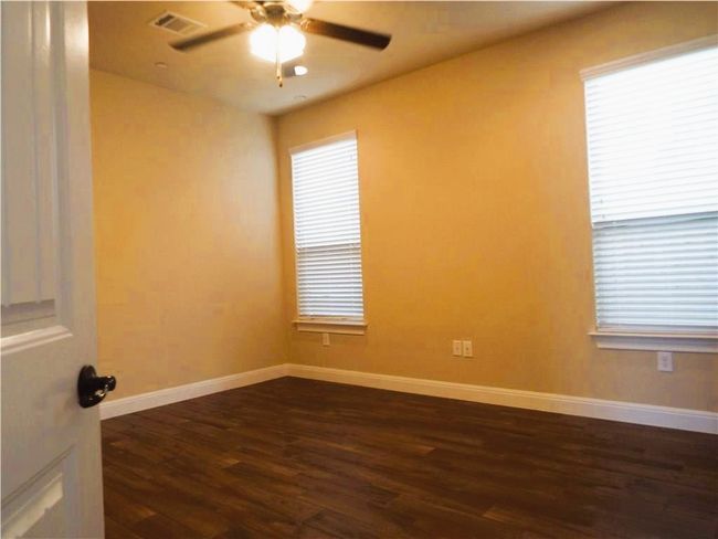 Unfurnished room featuring dark wood-style flooring, a ceiling fan, and baseboards | Image 8