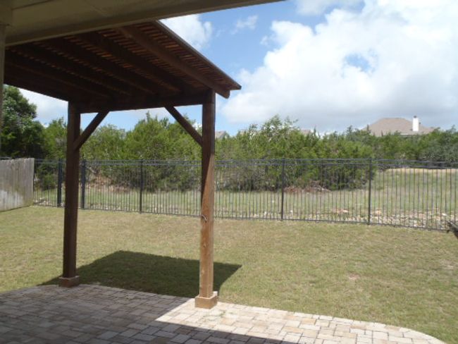 Fenced backyard with a patio | Image 6