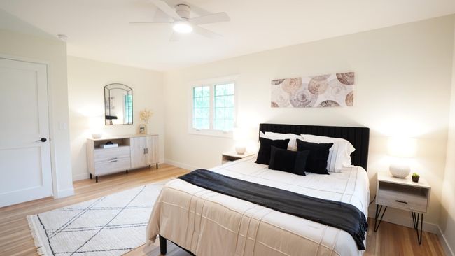 Located on the upper level, this spacious owners' bedroom is everything serene and convenient. Newly refinished white oak floors lay beneath the lightly painted walls, and the versatile dresser nook could easily double as a sitting area. | Image 23