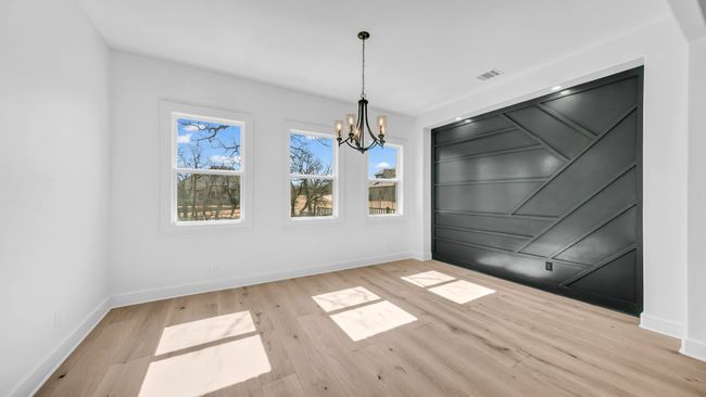Unfurnished dining area featuring visible vents, baseboards, a notable chandelier, and wood finished floors | Image 12