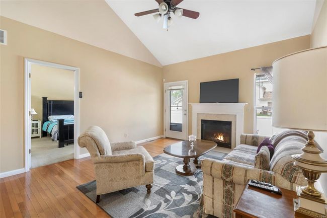 Kitchen with lofted ceiling, a sink, dishwasher, a fireplace, and a ceiling fan | Image 4