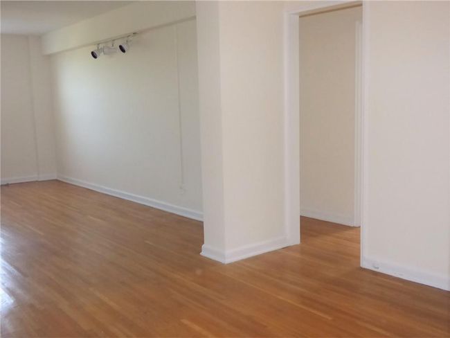 Living room/dining area with track lighting, baseboards, and wood finished floors | Image 19