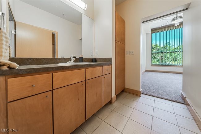 Bathroom featuring tile flooring, vanity, storage, tub and shower. | Image 32