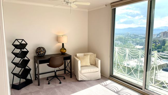 Carpeted office space featuring crown molding, a mountain view, a ceiling fan, and a view of city | Image 30