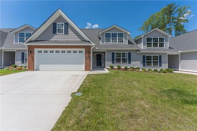 View of front of home featuring a front yard and a garage | Image 1