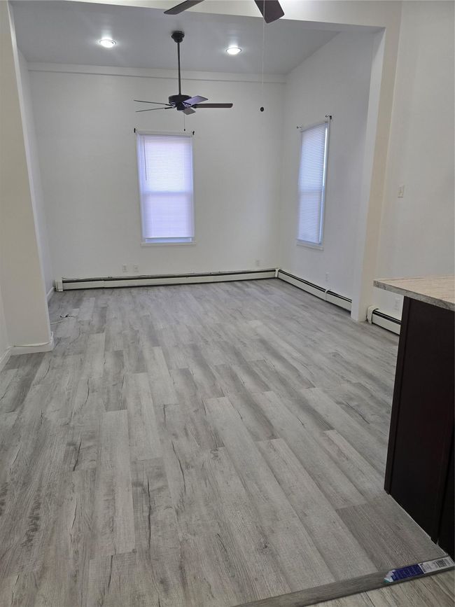 Empty room featuring ceiling fan, light wood finished floors, and plenty of natural light | Image 11