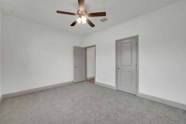 Unfurnished bedroom featuring ceiling fan, visible vents, baseboards, and carpet floors | Image 14